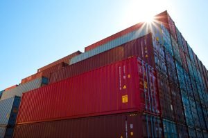A stack of blue and red shipping containers lined up ready to be shipped