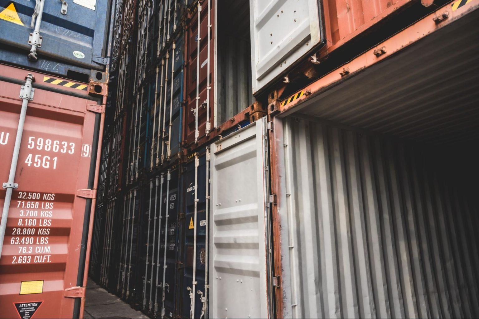 Open shipping container lined up with other shipping containers
