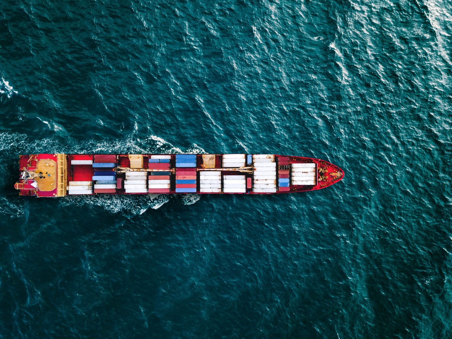An aerial image of a container ship sailing the seas.
